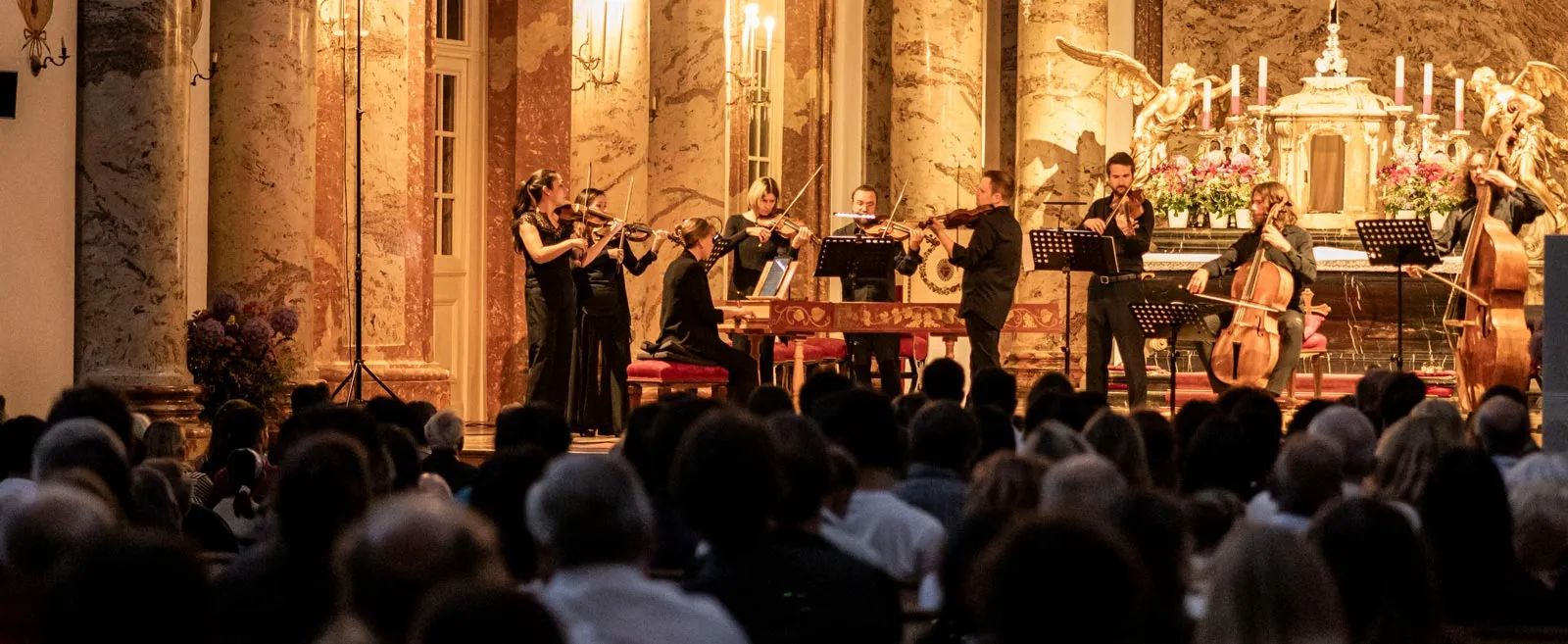 Orchester 1756 playing beneath the gilded marble of the Karlskirche, the audience in the foreground.